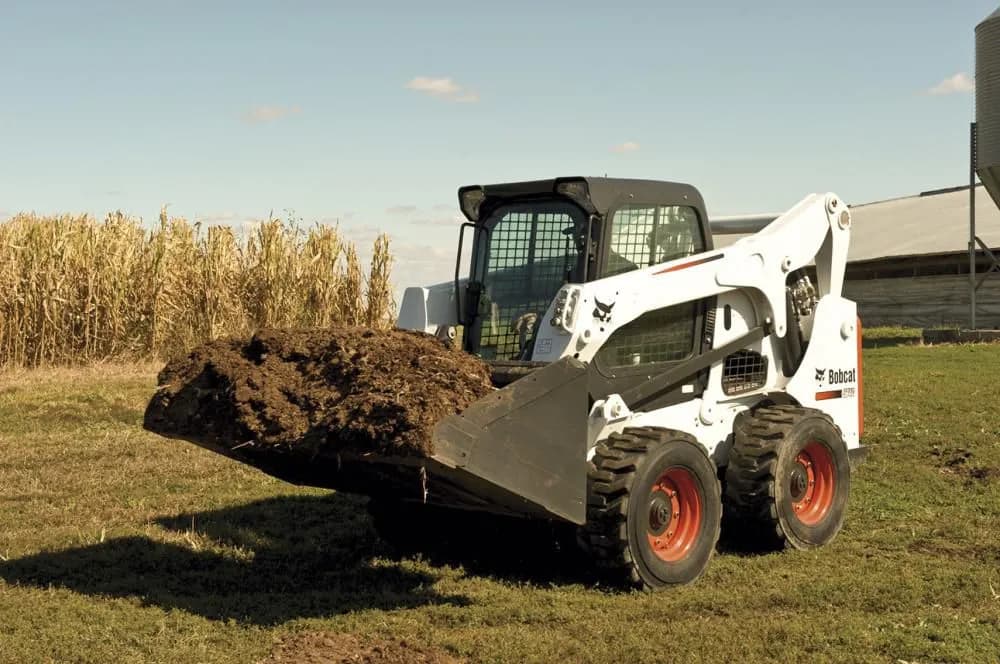 Bobcat skid steer loading soil in a farm field near Wilder, Idaho